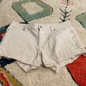 These are white stainless jeans shorts with flowers detailing pockets